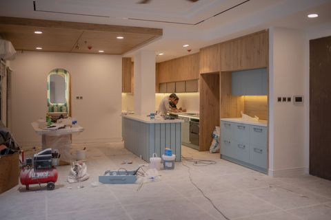 A kitchen in the middle of a renovation with tools on the floor