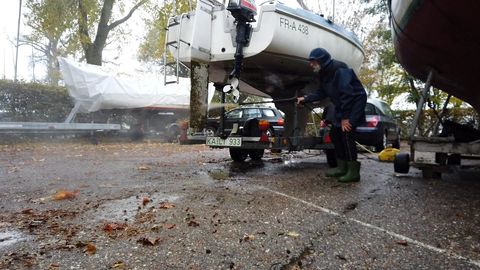 A mechanic washing down the hull of a boat